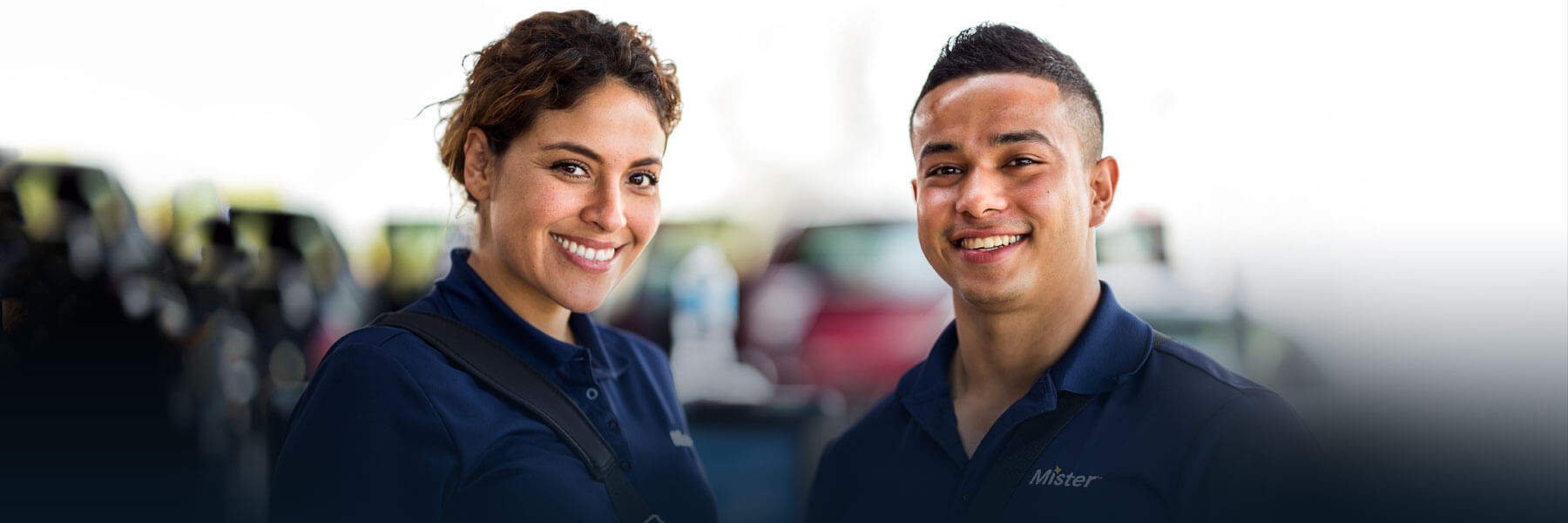 Two smiling Mister Car Wash employees